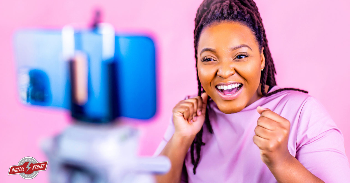 TikTok for Business - a woman excitedly looks at a camera. Pink background. Digital Strike - Targeted Marketing logo in the bottom left-hand corner.