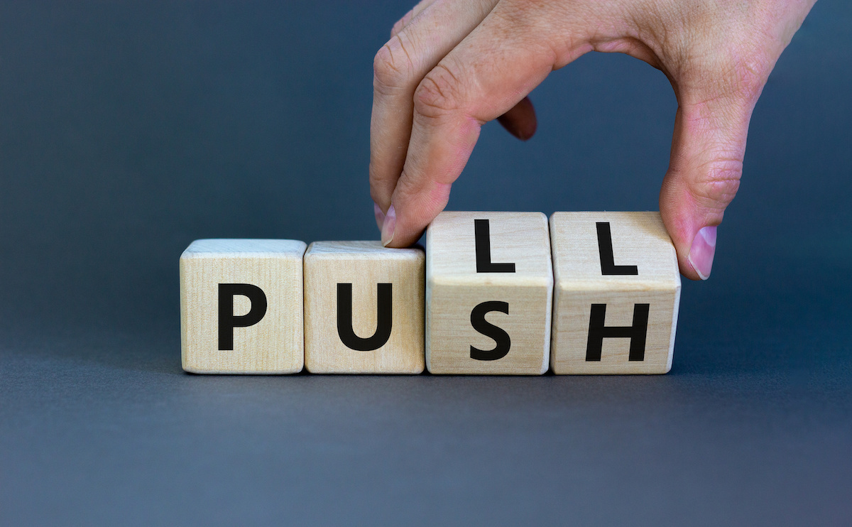 Content marketing expert turns wooden cubes and changes the word 'push' to 'pull'