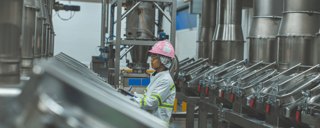 A man in PPE examines a manufacturing and industrial warehouse.