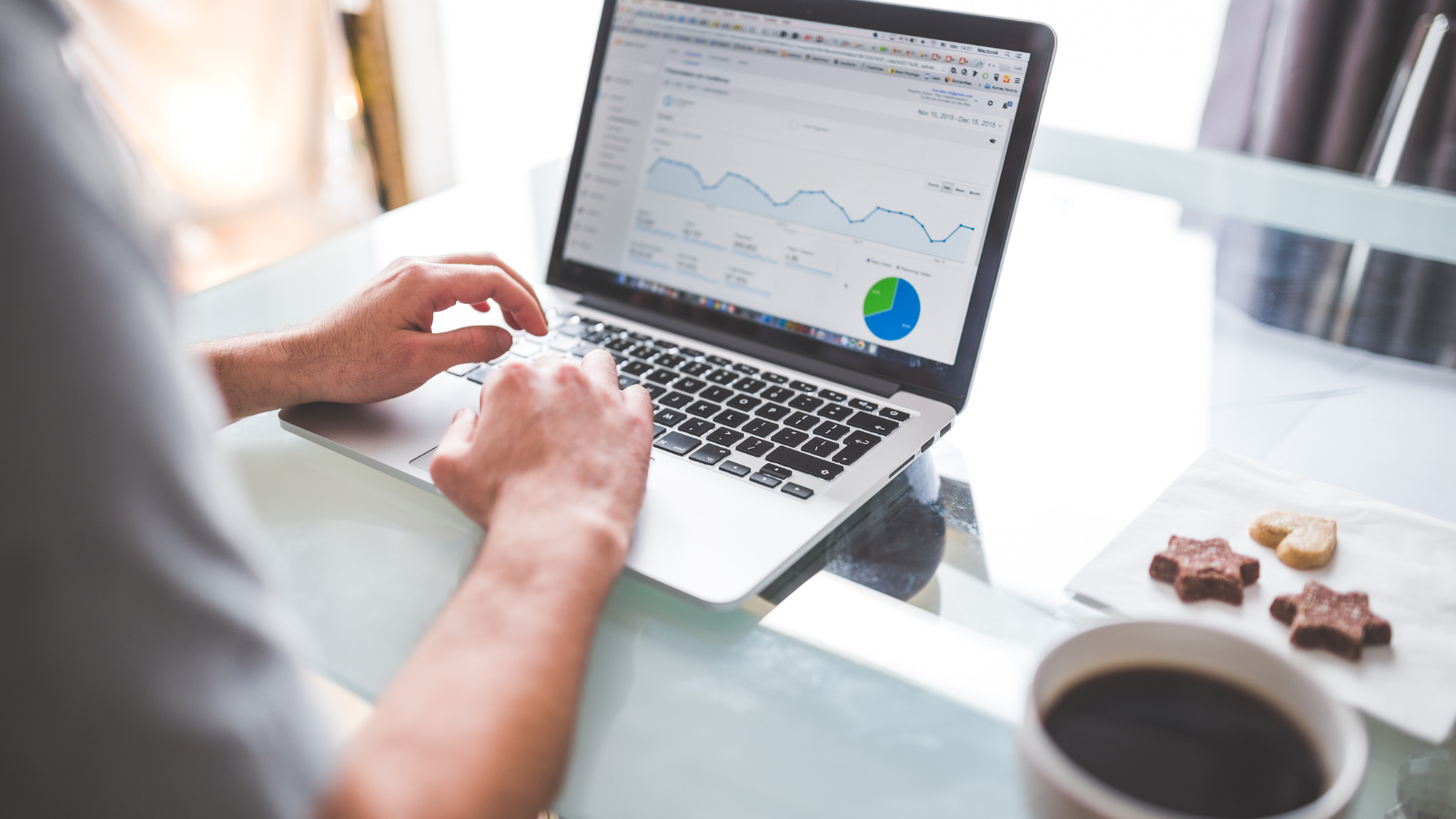 A man works on a laptop with an ad dashboard, showing how long it takes Google Ads to work.